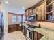 Updated kitchen features stainless steel appliances, granite counters, wood cabinets and hardwood flooring at 7890 S Quatar, Aurora, CO 80016