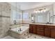 Elegant bathroom with soaking tub, glass shower, tile surround, and granite topped vanity with dual sinks at 16117 Ledge Rock Dr, Parker, CO 80134