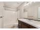 Bathroom featuring a shower-tub combo, dark vanity with a white countertop, and a decorative mirror at 16117 Ledge Rock Dr, Parker, CO 80134