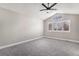 Spacious bedroom with vaulted ceiling, ceiling fan, neutral carpet, and window with louvered shutters at 16117 Ledge Rock Dr, Parker, CO 80134