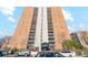 A tall brick apartment building stands under a blue sky with minimal landscaping around the entrance at 955 Eudora St # 801E, Denver, CO 80220