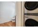 A utility room featuring a stacked washer and dryer located next to a half bathroom at 4085 S Crystal Cir # 104, Aurora, CO 80014