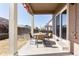 Relaxing covered patio with outdoor dining table, chairs, and landscaped yard at 3488 Purcell St, Brighton, CO 80601