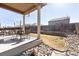 Covered backyard patio with outdoor dining table, chairs and beautifully landscaped yard at 3488 Purcell St, Brighton, CO 80601