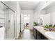 Well-lit bathroom featuring a glass shower, double sink vanity, and tile flooring at 3488 Purcell St, Brighton, CO 80601