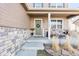 Inviting front porch with stylish seating, stone accents, and a welcoming wreath on the door at 3488 Purcell St, Brighton, CO 80601