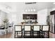 Modern kitchen featuring a large island with seating, stainless steel appliances, and dining area at 3488 Purcell St, Brighton, CO 80601