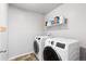 Laundry room with side by side white washer and dryer and shelf with laundry supplies at 3488 Purcell St, Brighton, CO 80601