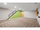 Finished basement includes carpeted floors, a stairwell with iron banisters and a green accent wall at 4511 Meade St, Denver, CO 80211