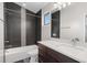 Bathroom features a shower and bathtub with gray tile, a white quartz countertop and sink at 4511 Meade St, Denver, CO 80211