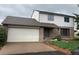 Two-story home with a brick and siding exterior, attached garage, and a well-maintained front lawn at 12904 N 3Rd St, Parker, CO 80134