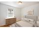 Neutral bedroom showcasing hardwood floors, a large window, and simple, stylish decor at 1355 Rosemary St, Denver, CO 80220
