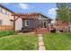 View of the backyard, featuring a hot tub, pergola, outdoor patio, and stone path to the lawn at 3341 Newton St, Denver, CO 80211