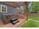 Backyard featuring a hot tub, deck with stairs, grill, and grassy area at 3341 Newton St, Denver, CO 80211
