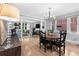 Well-lit dining room with hardwood floors, stylish chandelier, and a seamless flow into the living area at 3341 Newton St, Denver, CO 80211