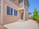 Home exterior featuring light brown and green siding, multiple windows, and concrete patio at 17186 E Cedar Gulch Dr, Parker, CO 80134