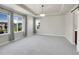 Bright main bedroom featuring large windows, tray ceilings, and neutral carpeting at 17186 E Cedar Gulch Dr, Parker, CO 80134