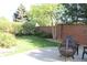 Serene backyard with lush greenery, a brick fence and a cozy patio seating area at 1710 S Poplar St, Denver, CO 80224