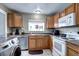 Kitchen with wood cabinets, white appliances, and a window at 2391 Lansing St, Aurora, CO 80010