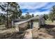 Home exterior features a greenhouse and a brick walkway leading to a blue front door at 4295 Picutis Rd, Indian Hills, CO 80454
