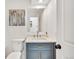 Stylish bathroom featuring a blue vanity with a marble countertop, a modern mirror, and a neutral color scheme at 8095 Johnson Ct, Arvada, CO 80005