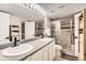 Bathroom featuring a dual sink vanity, granite countertops, and an enclosed glass shower at 1630 Egret Way, Superior, CO 80027
