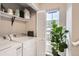 Well-organized laundry room with shelving, a large window, and ample natural light at 1630 Egret Way, Superior, CO 80027