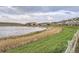 Scenic view of community pond surrounded by grassy landscapes and nearby homes at 1630 Egret Way, Superior, CO 80027