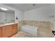 Bright bathroom featuring a built-in tiled tub and a traditional wood vanity at 7077 S Bryant St, Littleton, CO 80120