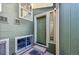 Front door of a home with green siding, window to the side of the door and stone landscaping at 7077 S Bryant St, Littleton, CO 80120