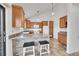 Kitchen featuring wooden cabinets, white appliances, bar seating, and a sliding glass door to the exterior at 7077 S Bryant St, Littleton, CO 80120