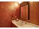 Stylish half bath with decorative mirror, textured walls, and white countertop at 16627 W 1St Ave, Golden, CO 80401