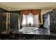 Luxurious bathroom featuring a jacuzzi tub and a marble shower enclosure at 16627 W 1St Ave, Golden, CO 80401
