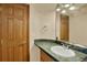 Well-lit bathroom with vanity, marble counters, and wood door at 16627 W 1St Ave, Golden, CO 80401