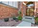 Brick home entrance featuring a secured doorway, potted plants, and decorative rock landscaping at 16627 W 1St Ave, Golden, CO 80401
