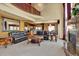Open-concept living room with fireplace, leather sofas, grand chandelier, and staircase in view at 16627 W 1St Ave, Golden, CO 80401