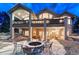 Expansive backyard featuring a stone fire pit area and covered patio, ideal for outdoor gatherings at 1127 Buttermilk Rd, Larkspur, CO 80118