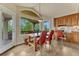 Dining area with a view of trees and wood floors, dining table and red chairs at 1127 Buttermilk Rd, Larkspur, CO 80118