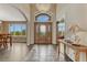 Inviting home foyer with hardwood floors, decorative front door, and a large window at 1127 Buttermilk Rd, Larkspur, CO 80118