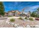Beautiful home with decorative statue, well-manicured lawn, and rock landscaping at 1127 Buttermilk Rd, Larkspur, CO 80118