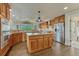 Spacious kitchen with stainless steel appliances, wood cabinetry and island at 1127 Buttermilk Rd, Larkspur, CO 80118