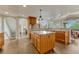 Bright kitchen features wood cabinets, island with granite countertops and wood floors at 1127 Buttermilk Rd, Larkspur, CO 80118