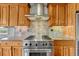 A stainless steel oven and range in a kitchen with tile backsplash at 1127 Buttermilk Rd, Larkspur, CO 80118