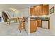 Kitchenette featuring wood cabinets, granite countertops, barstool seating, and staircase access at 1127 Buttermilk Rd, Larkspur, CO 80118
