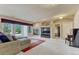 Spacious living room featuring a cozy fireplace, large windows, and a comfortable seating area with backyard views at 1127 Buttermilk Rd, Larkspur, CO 80118