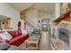 Cozy living room with hardwood floors, staircase, fireplace and a decorative light fixture at 1127 Buttermilk Rd, Larkspur, CO 80118