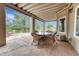 Charming covered patio with stone flooring, offering a comfortable outdoor dining area and scenic views of the surroundings at 1127 Buttermilk Rd, Larkspur, CO 80118