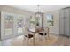 Cozy dining area with wood table, white chairs, modern light fixture, and natural light from the backyard patio access at 24738 E Layton Pl, Aurora, CO 80016