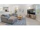 Comfortable living room with light-colored walls, hardwood floors, and open layout leading into the kitchen at 24738 E Layton Pl, Aurora, CO 80016