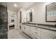 Contemporary bathroom with dual sinks, white cabinets, and an open doorway leading to the primary bedroom at 4950 Saddle Iron Rd, Castle Rock, CO 80104